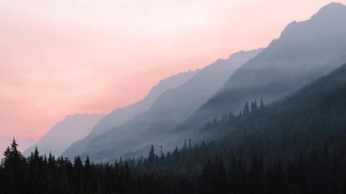 Hazy Pink Sunset Over Misty Mountains 4K Desktop Wallpaper