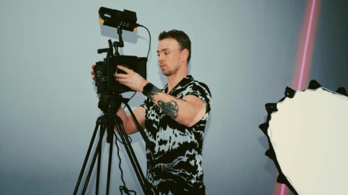 Professional Videographer Adjusting Cinema Camera 4K Wallpaper