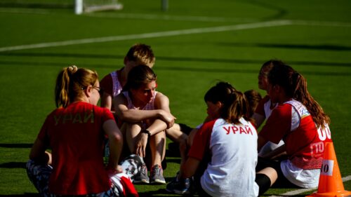 Team of Young Athletes Resting on Field Desktop Wallpaper