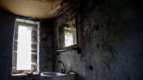 Eerie Abandoned Bathroom with Cobwebs and Gritty Atmosphere PC Wallpaper