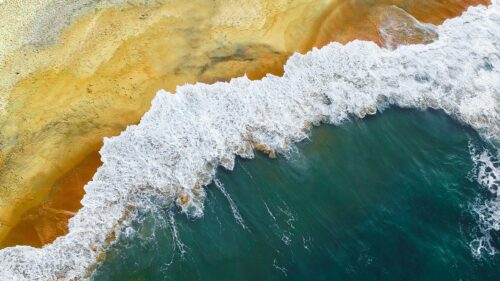 Aerial View of Sandy Beach and Turquoise Ocean Waves Desktop Wallpaper