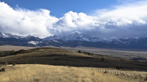 Stunning Snowy Mountain Range Over Golden Grassland PC Wallpaper
