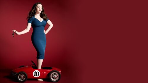 Kat Dennings in Blue Dress Standing on Red Toy Car 4K Desktop Wallpaper
