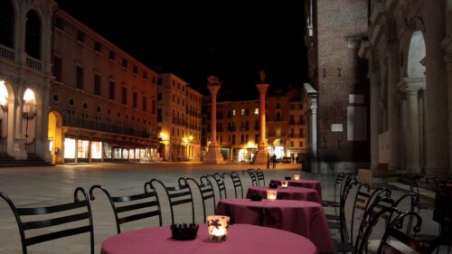 Night View of an Empty Italian Piazza with Cafe Tables 4K Wallpaper