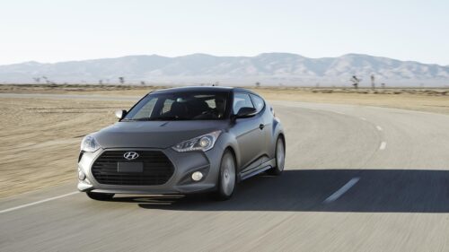 Matte Grey Hyundai Veloster Driving on Desert Road Desktop Wallpaper