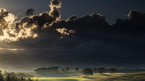 Dramatic Sunlit Clouds Over Rolling Hills Landscape PC Wallpaper