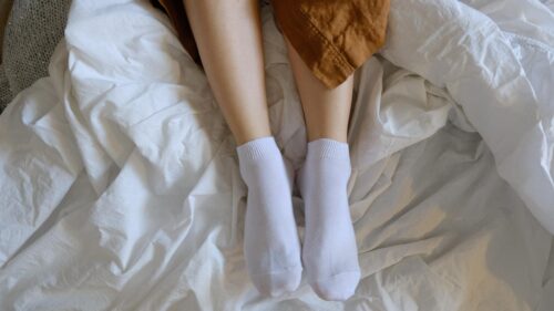 Relaxing Morning Vibes with Cozy White Socks on Bed Desktop Wallpaper
