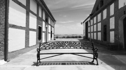 Rustic Iron Bench Between Traditional Buildings Black and White Desktop Wallpaper