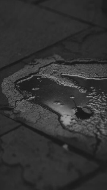 Puddle Of Water On Cracked Pavement - Mobile Wallpaper