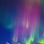 Aurora Borealis Over Snow-Capped Mountains at Night