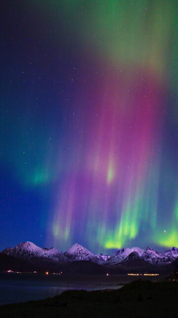 Aurora Borealis Over Snow-Capped Mountains at Night