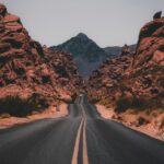 Desert Landscape: Black Concrete Road Surrounded by Brown Rocks