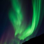 Aurora Borealis Over Dark Mountains