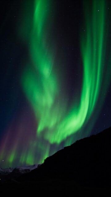 Aurora Borealis Over Dark Mountains