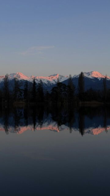 Snow-Capped Mountains Reflected in Still Water at Sunset