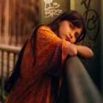 Vibrant Orange: Young Woman Leans on Railing