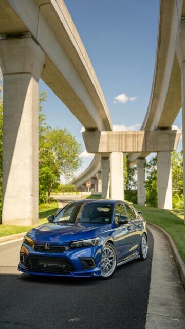 Urban Oasis: Blue Sedan Under Concrete Overpass