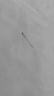 Shadowy Focus: A Single Nail on a Wall