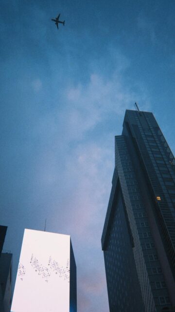 Airplane Over Modern Cityscape