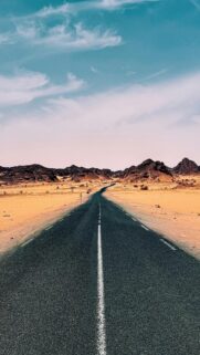 Endless Horizon: Desert Road to Mountainous Skies