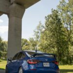 Urban Oasis - Blue Sports Sedan Parked Under A Concrete Overpass