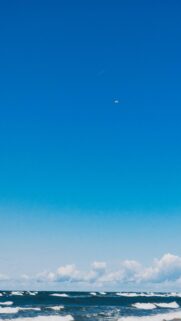 Stunning Ocean View: Bright Blue Sky and White Clouds