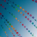 Vibrant Paper Flags Against A Bright Blue Sky
