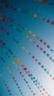 Vibrant Paper Flags Against A Bright Blue Sky
