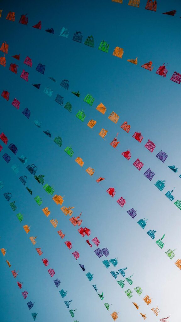 Vibrant Paper Flags Against A Bright Blue Sky