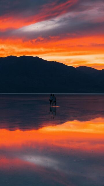 Sunset Reflections: Couple Standing On Water
