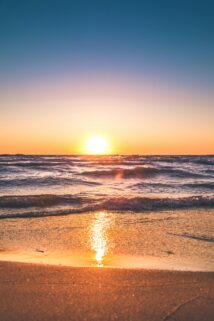 Experience The Serene Sunset Over Ludington Beach With Vibrant Colors And Tranquil Waves – Free 4K HD Download