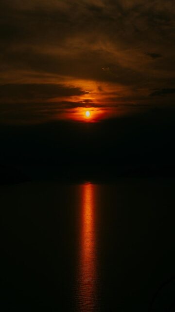 Stunning Fiery Sunset Over Dark Ocean Water Wallpaper