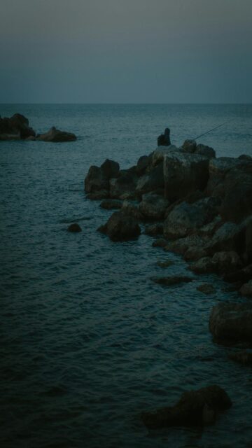 Coastal Peace: Fisherman at Dusk