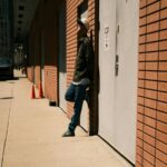 Urban Oasis - Man Leaning Against Brick Building