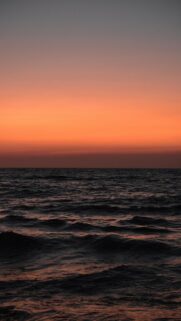 Vibrant Orange Sunset Sky Over Ocean Waves
