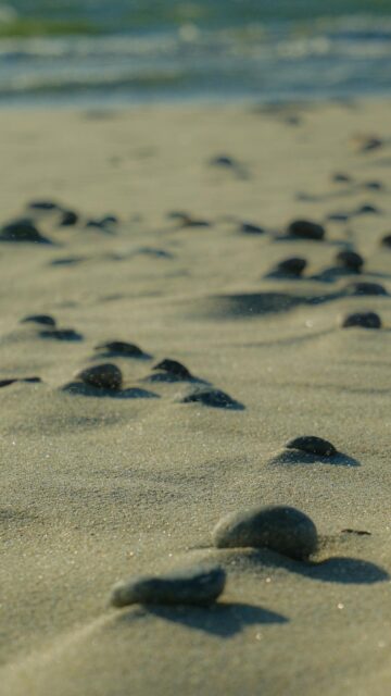 Scenic Ocean View: Pebbles on Sandy Beach