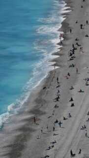Turquoise Bliss: People Relaxing on Pebble Beach