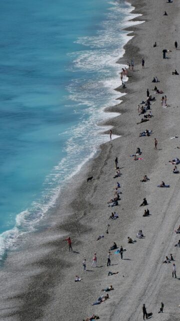 Turquoise Bliss: People Relaxing on Pebble Beach