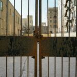 Rusty Metal Gate with Buildings in Background