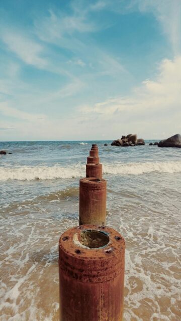 Beach Vibes: Ocean Waves Meet Rusty Posts