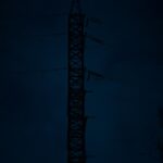 Tall Power Line Tower Silhouette at Night