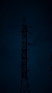 Tall Power Line Tower Silhouette at Night