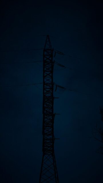 Tall Power Line Tower Silhouette at Night