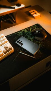 Golden Hour Workspace: Smartphone and Stylus on Desk with Keyboard and Mouse