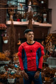 Smiling Young Man Wearing A Spider Man Costume In A Vibrant Garden Setting – Free 4K HD Download