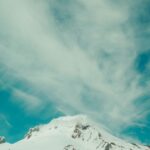 Snow-Covered Mountain Peak Under a Cloudy Sky