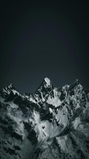 Breathtaking Snow-Covered Mountains Under A Dark Sky