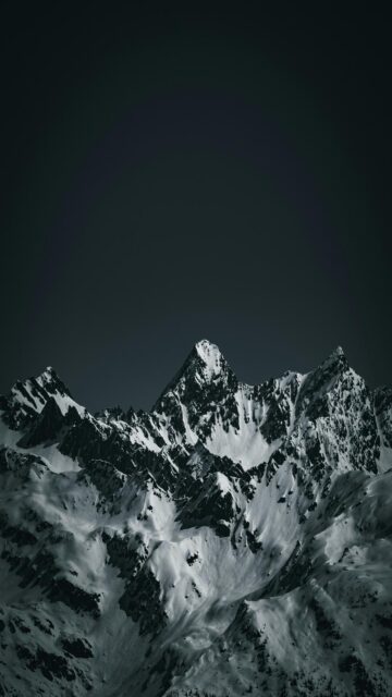 Breathtaking Snow-Covered Mountains Under A Dark Sky