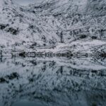 snow-covered-mountains-reflected-in-dark-lake