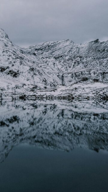 snow-covered-mountains-reflected-in-dark-lake